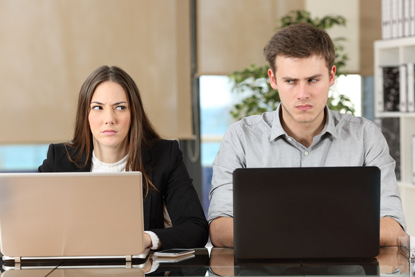 Two employees working at their laptops.
